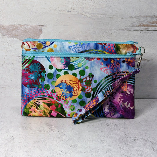 Rectangular zippered pouch, with two zippers and a wristlet strap attached with a swivel clip